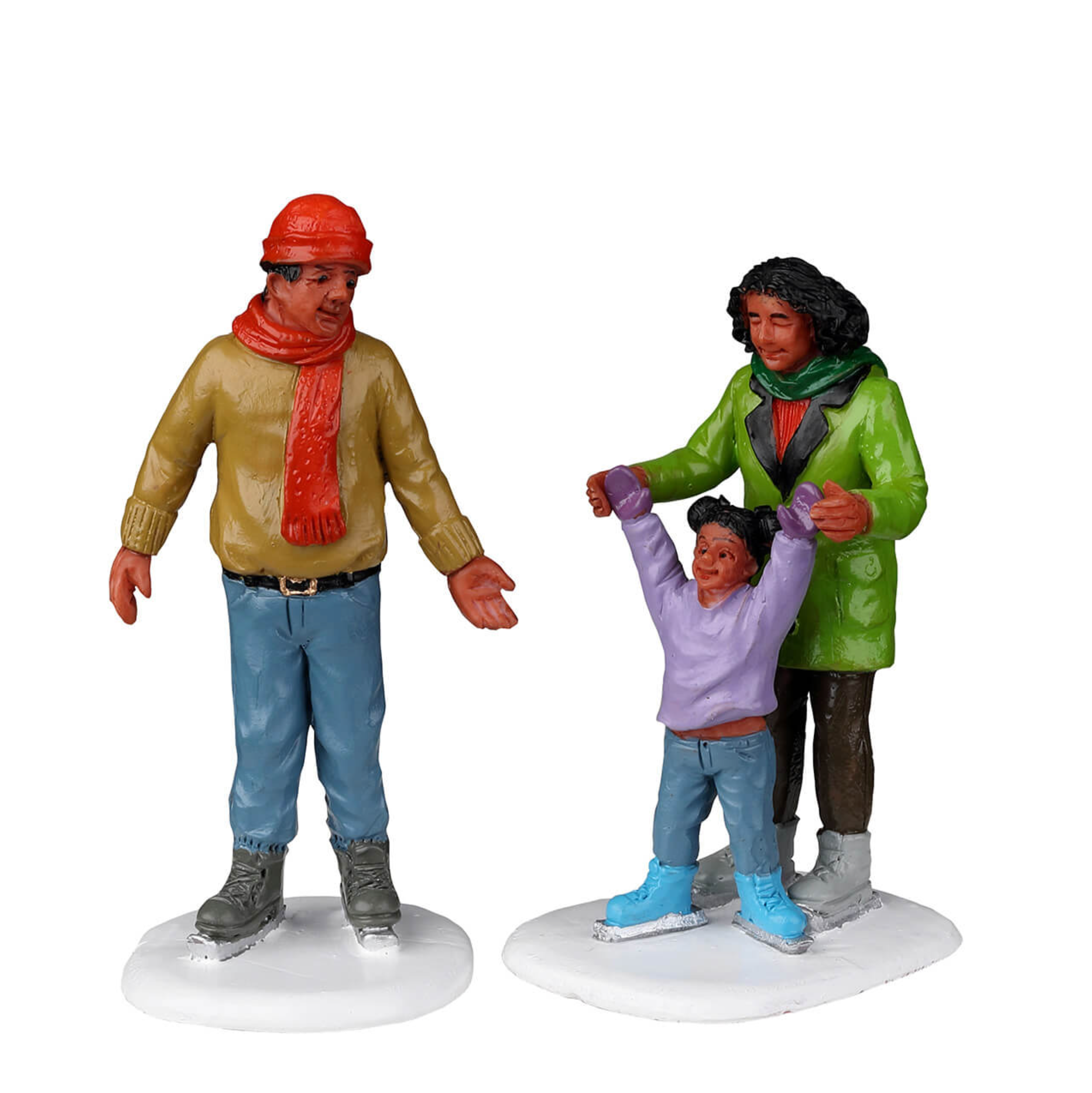 Three figurines of a man, woman, and child on ice skates against a white background