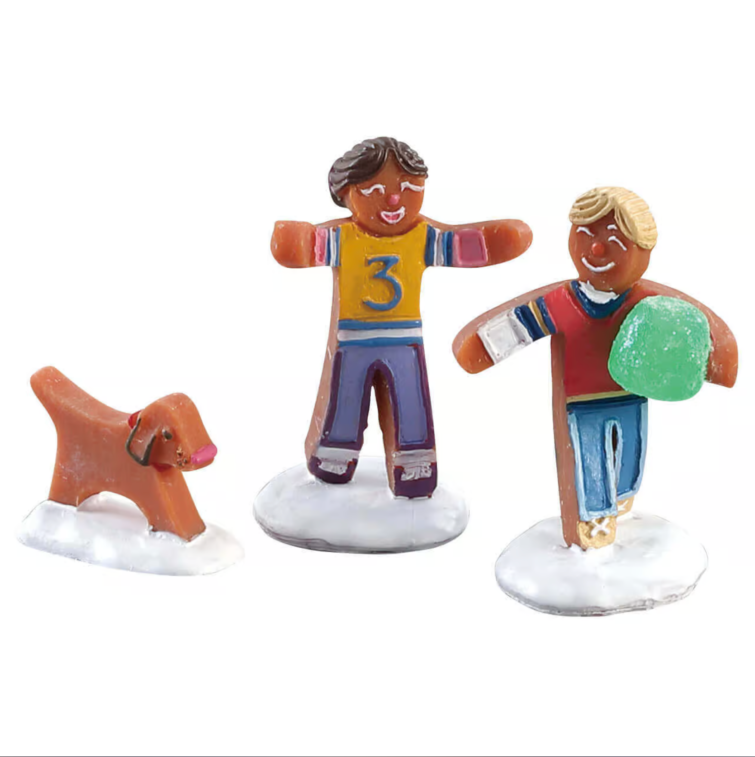Two figurines of ginigerbread children playing with a dog on a white background