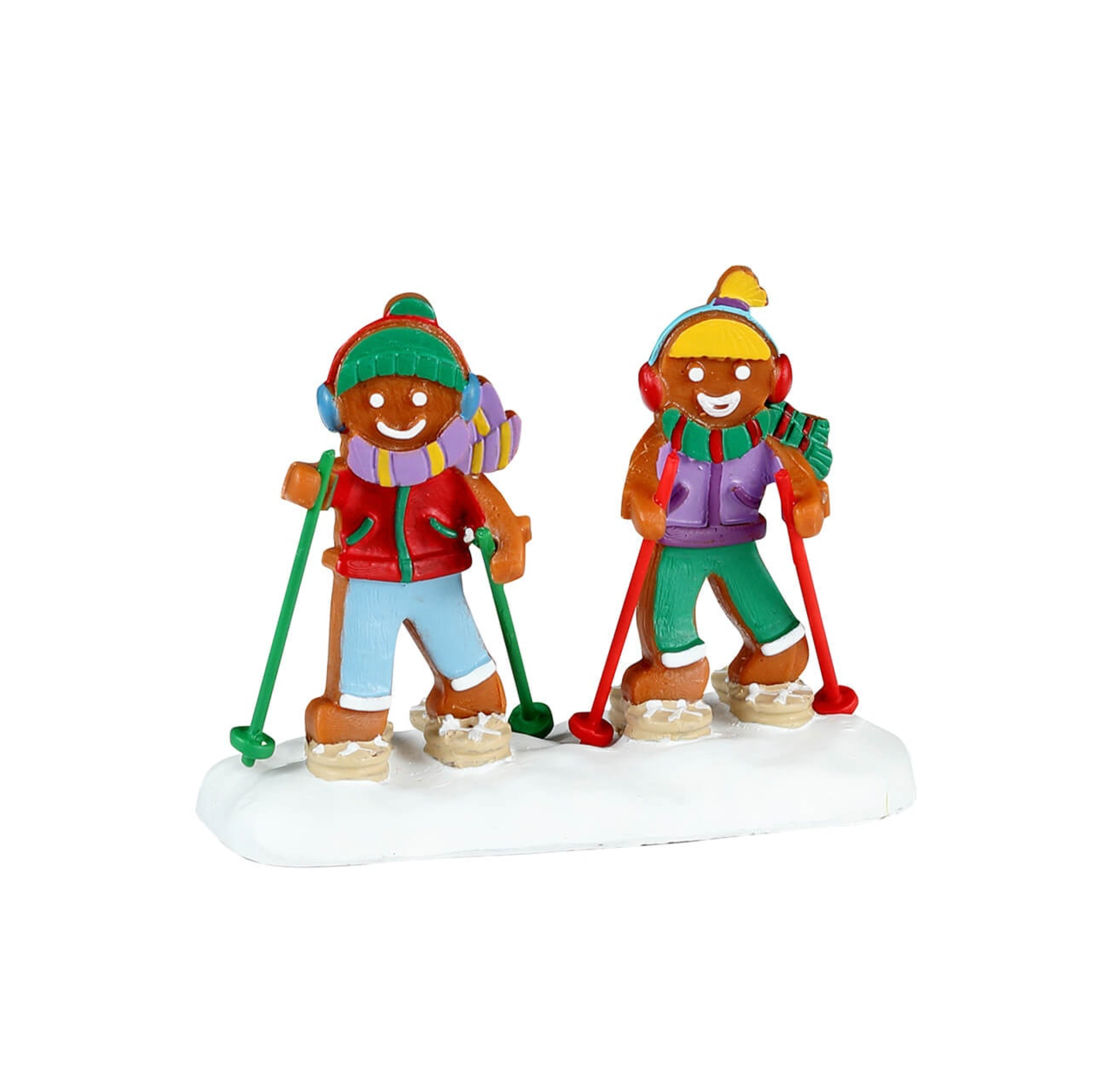 Two Lemax figurines of gingerbread children skiing on a white background