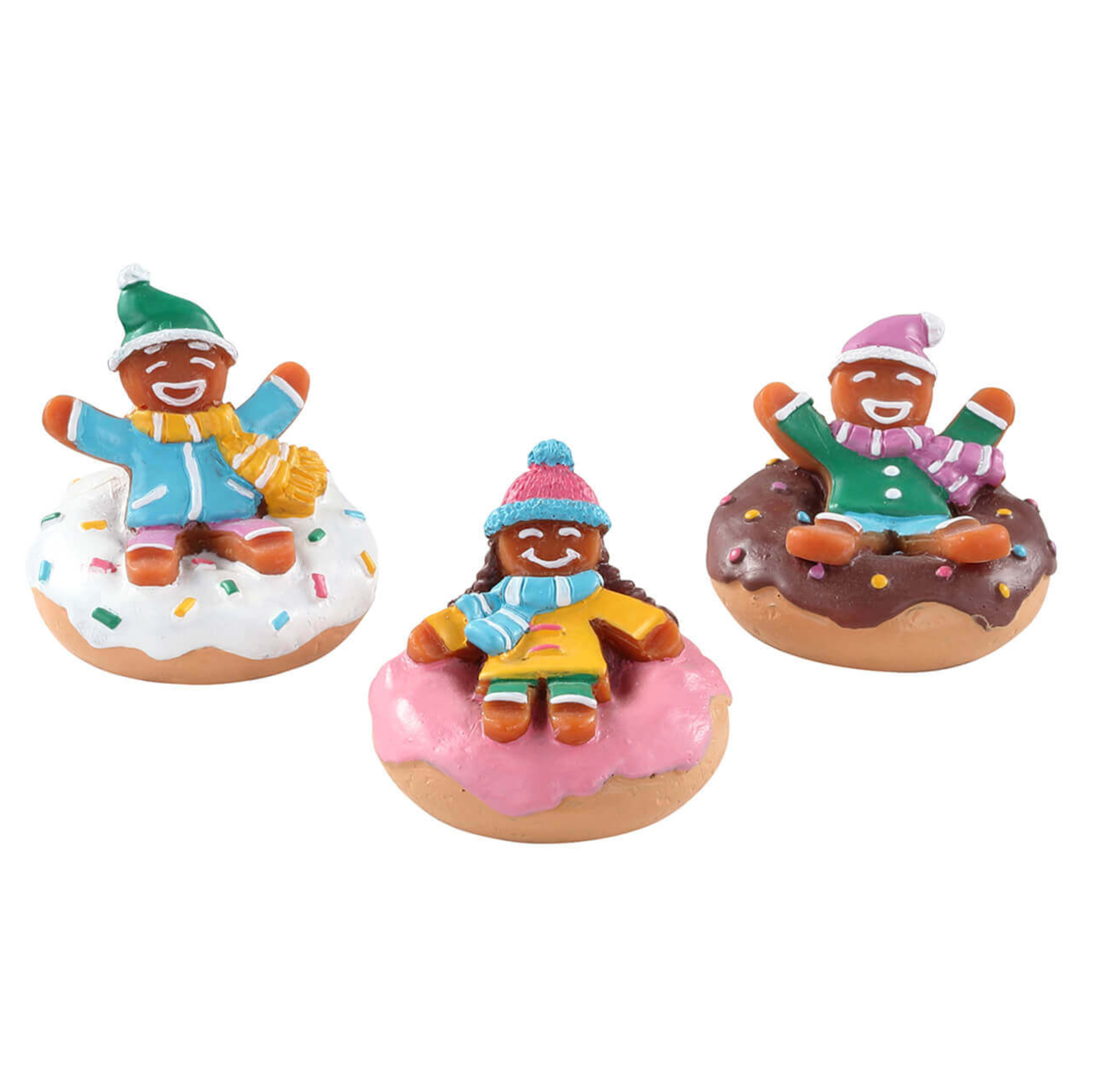 Three small Lemax figurines of gingerbread people on donuts snow tubes with different toppings and colors.